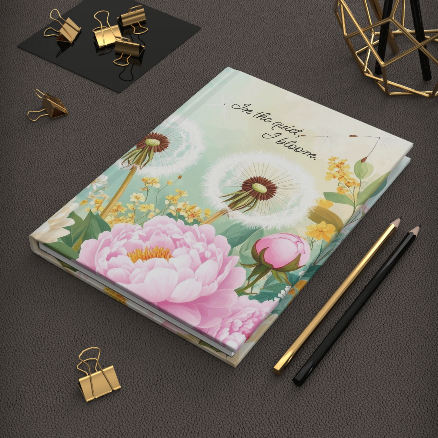 Journal angled on desk surface, pairing floral cover with soft neutral background.