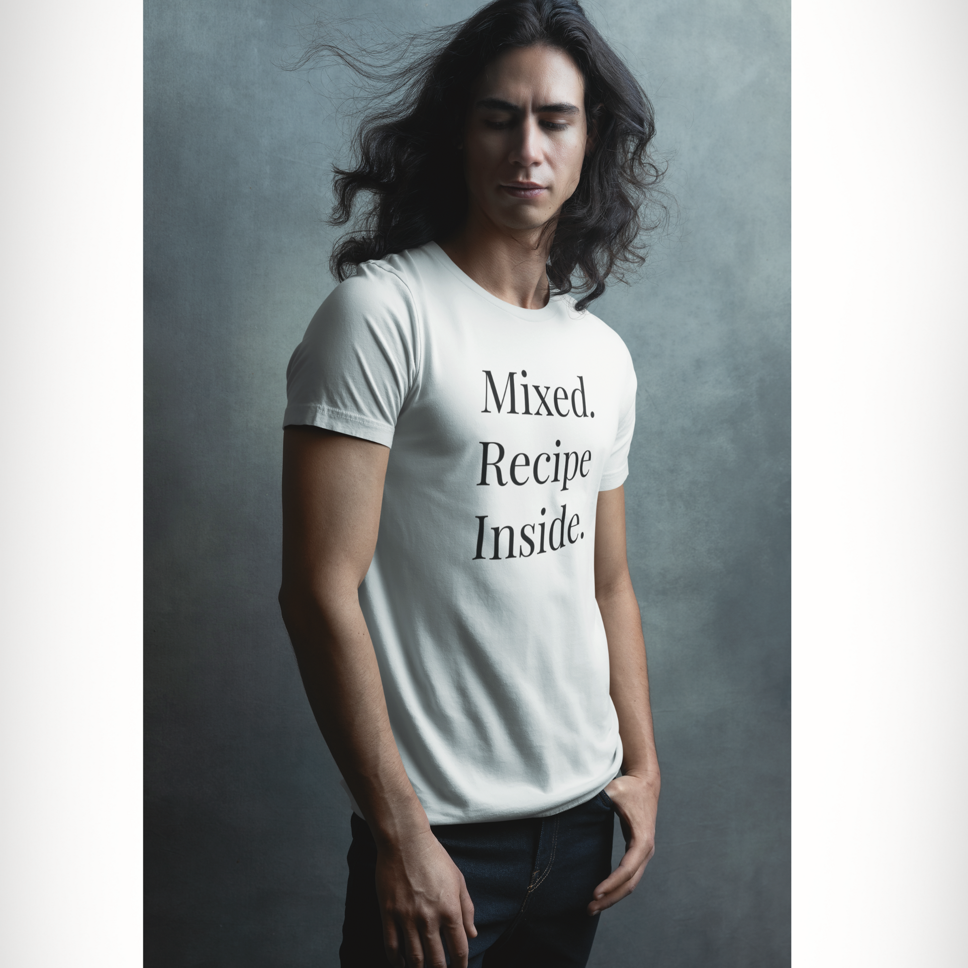 Man with long, flowing hair wearing a white Signature Tee with 'Mixed. Recipe Inside.' text on a gray background.