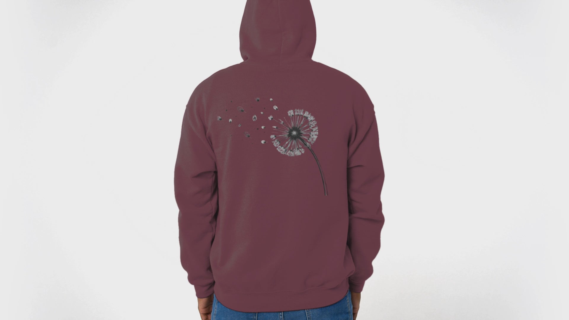 Back view video of man wearing maroon drift different hoodie. He takes the hood down and looks from side to side.